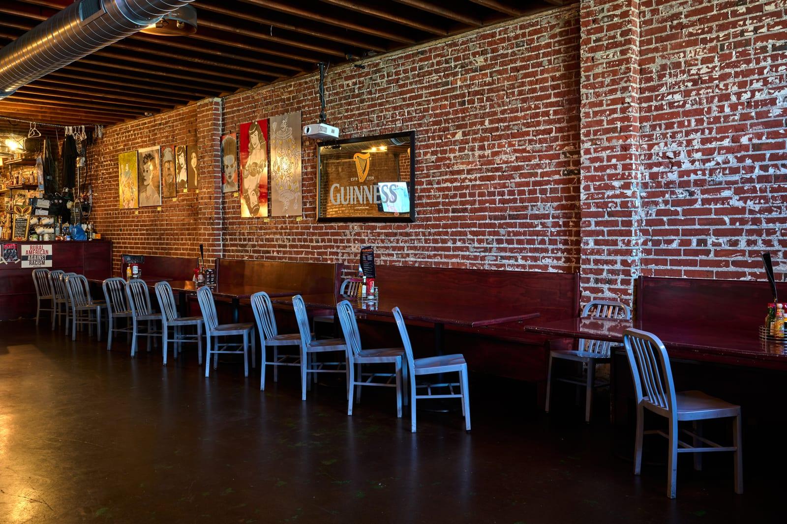 McFiler's downtown Chehalis: long bench seating along an exposed-brick wall under a vintage Guinness mirror — trivia and karaoke teams meet here