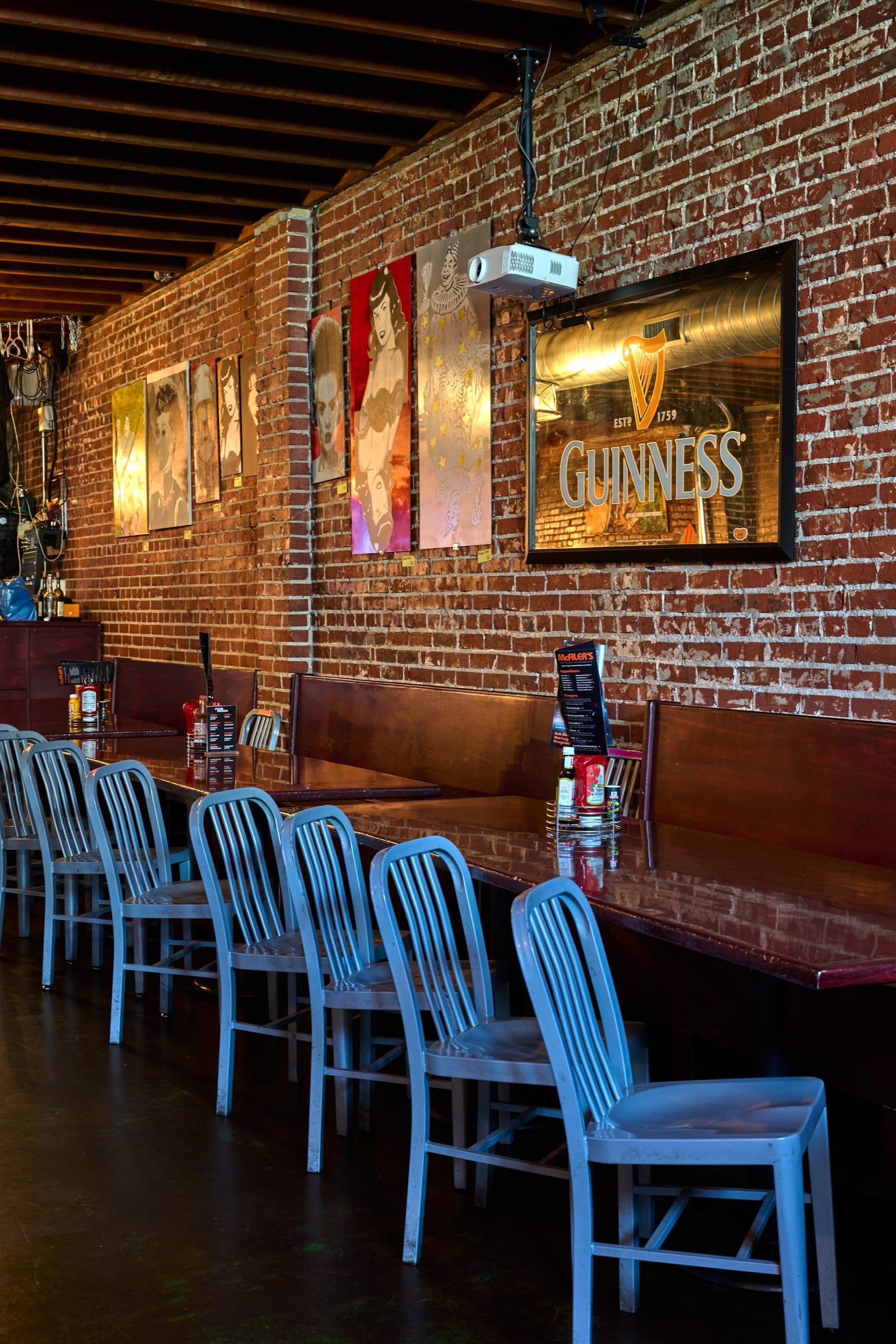 Inside McFiler's in Chehalis, WA: exposed brick walls, pop-art posters, vintage Guinness mirror and blue school-chair bar seating